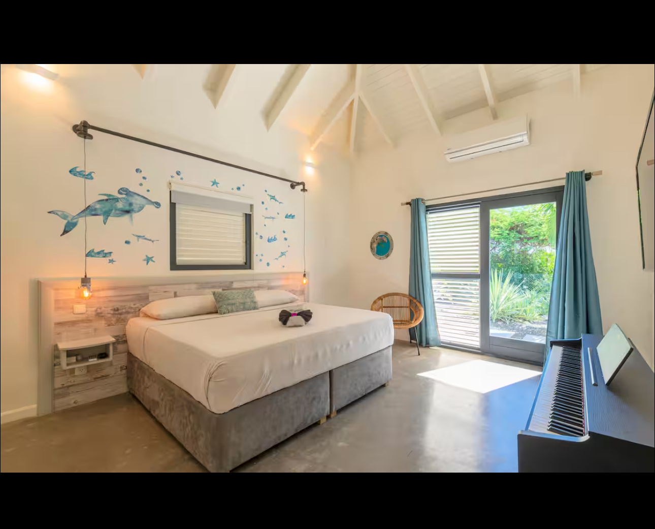 Bright bedroom with ocean-inspired wall art and garden doors