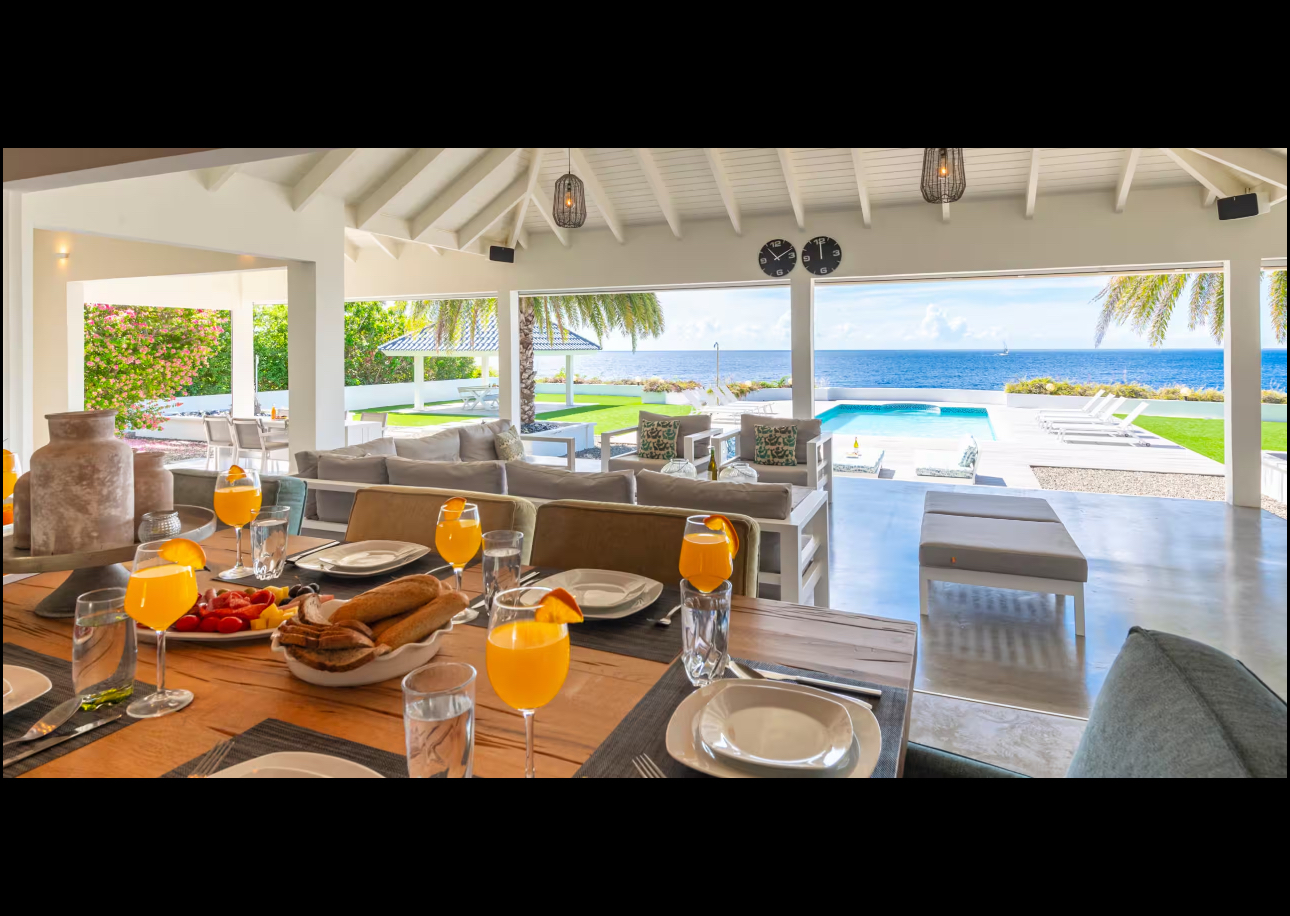 Dining table and open living area with an ocean view